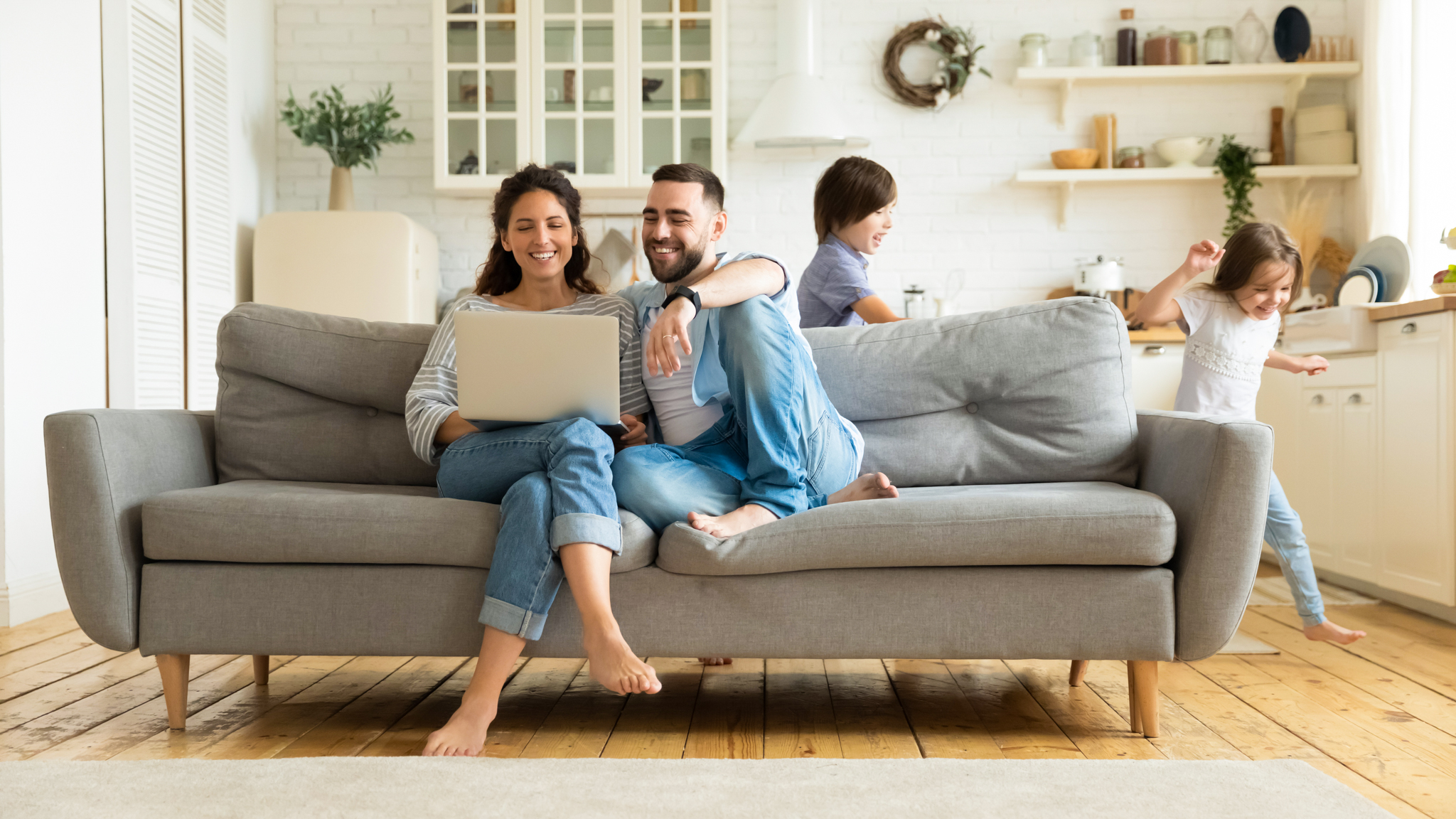 Koppel houdt elkaar liefdevol vast in hun woonkamer terwijl ze terugdenken aan hun succesvolle vergelijking voor vaste kosten die ze deden op Mijnvergelijker.be.